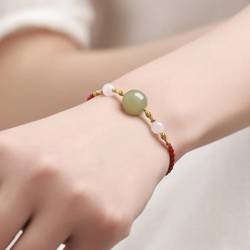 Lucky bracelet with jade bead worn on right wrist, side profile view