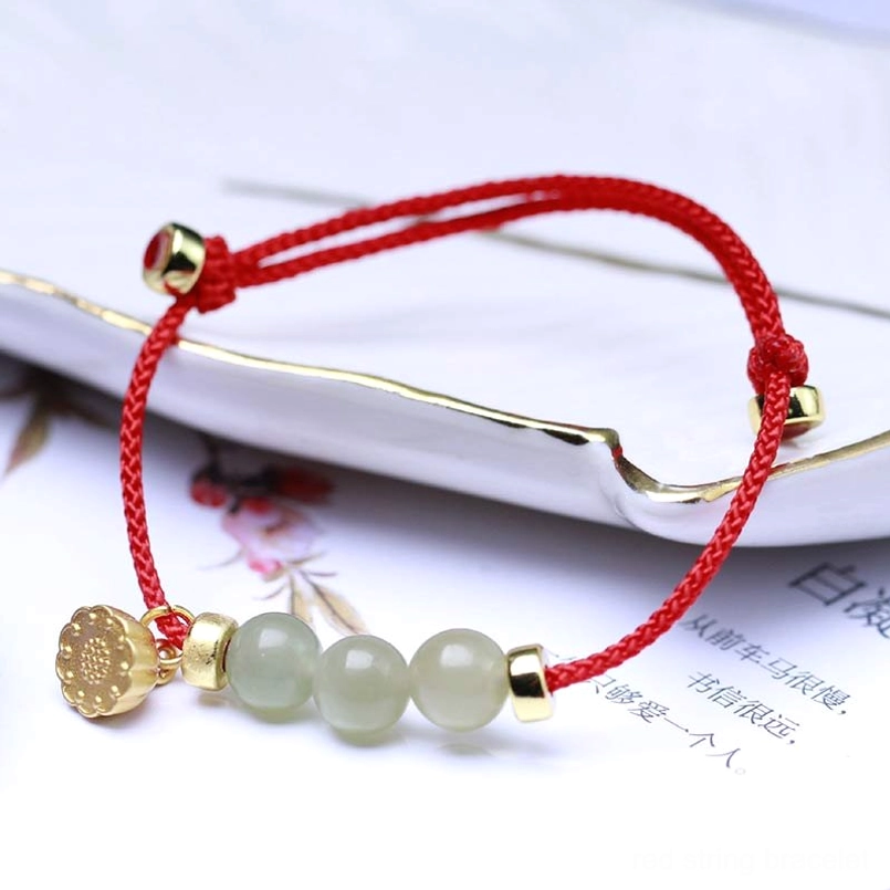 Red jade lotus bracelet with sliding knot closure showing three jade beads and gold charm