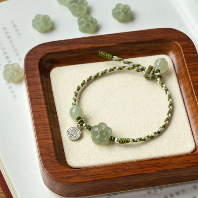 Complete jade plum blossom bracelet design with loose beads arrangement on book display