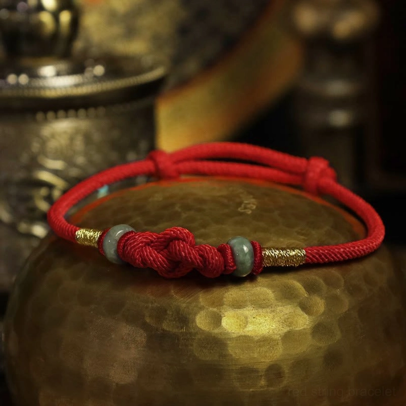 Red string jade beaded bracelet with gold rings and prosperity knot