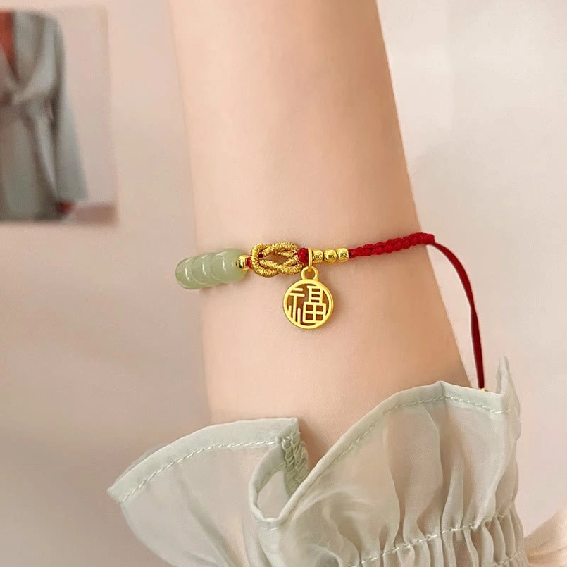 Handcrafted jade fu character bracelet showing natural bead variation and twisted knot design