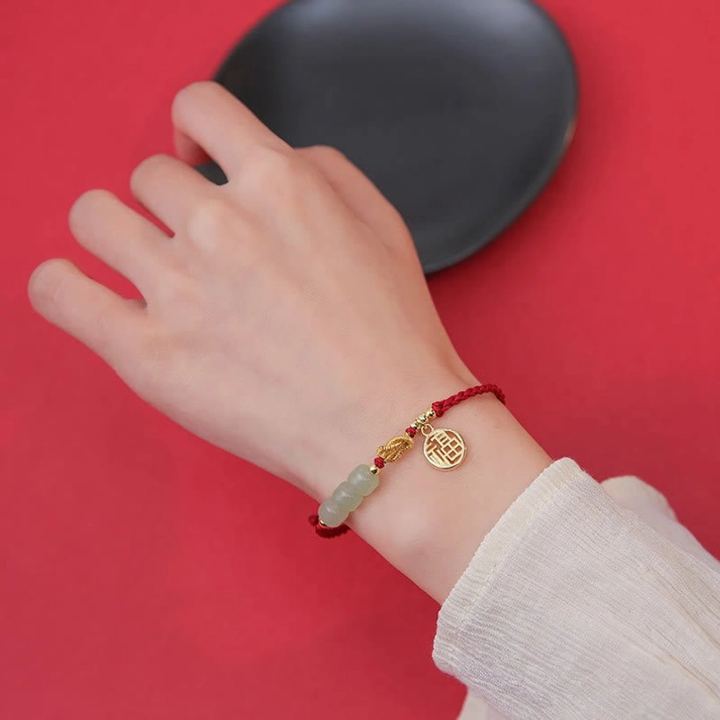 Jade fu character red string bracelet worn on wrist showing proper fit and comfort