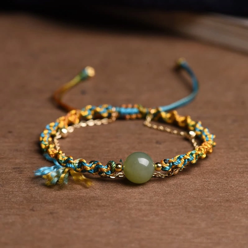 Double-layer jade lucky bracelet flat lay overhead with blue and gold braided cord and green jade bead