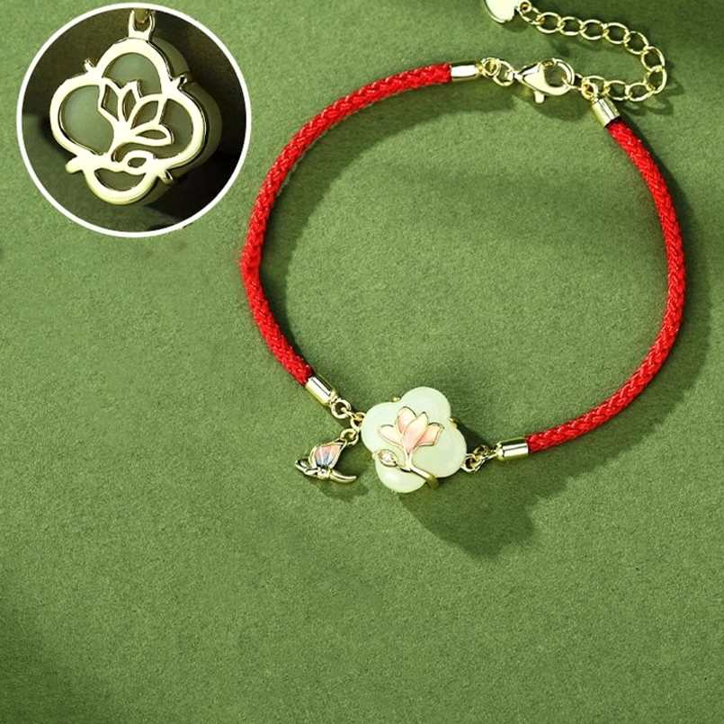 Hetian jade magnolia butterfly bracelet angled overhead view full display red string