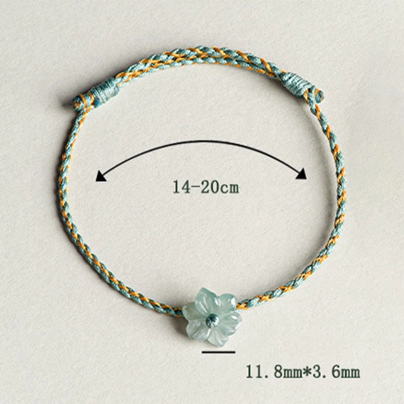Green string jade orchid bracelet placed on soft neutral fabric background