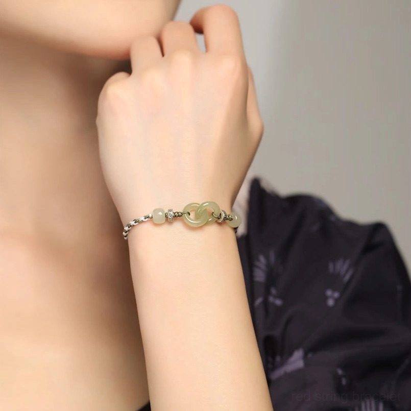 Woman wearing hetian jade peace buckle bracelet with interlocking jade buckles on wrist
