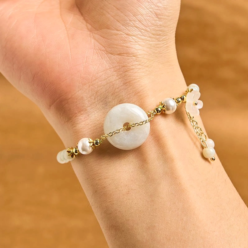 Jade peace buckle bracelet worn on wrist showing adjustable red string and gold hardware