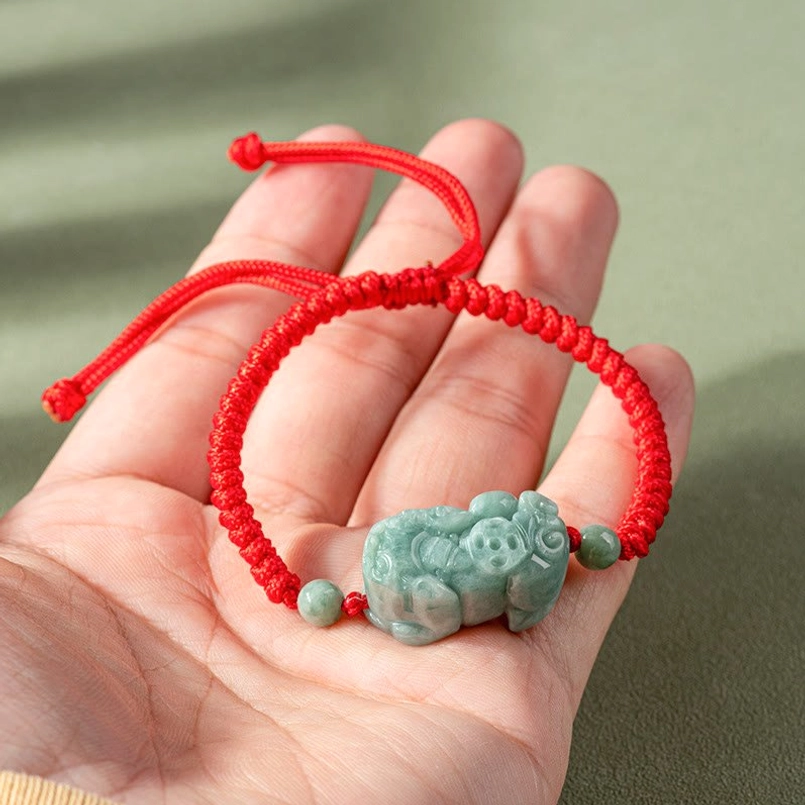 Handmade King Kong knot red string bracelet held in palm, showing compact woven design
