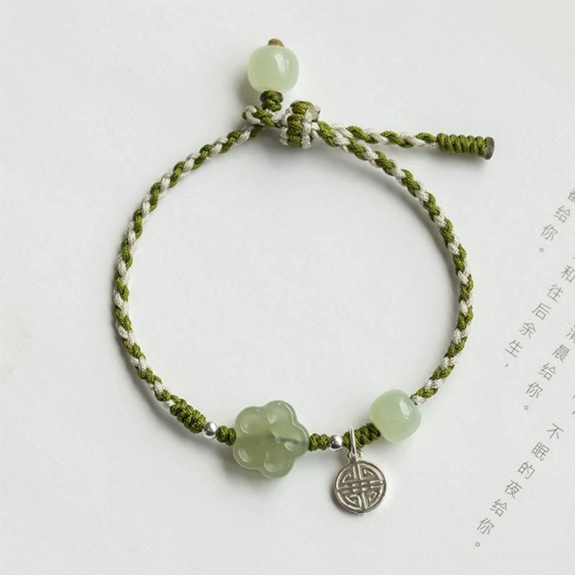 Jade plum blossom bracelet flat lay with adjustable braided cord and round jade beads detail