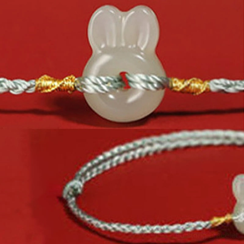 Close-up detail of jade rabbit pendant with braided rope and twisted gold accents
