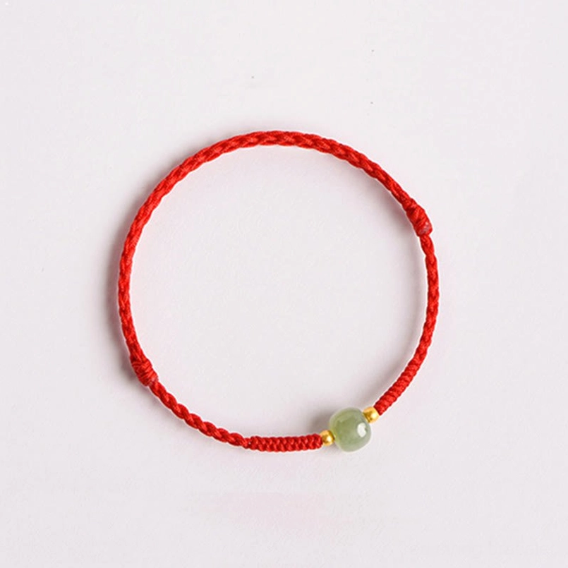 Classic jade lucky charm bracelet with braided red cord - flat lay top down