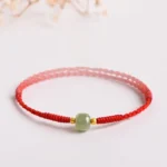Handmade jade red string prosperity bracelet with gold spacers - three-quarter view