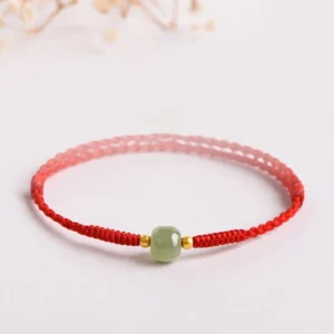 Handmade jade red string prosperity bracelet with gold spacers - three-quarter view