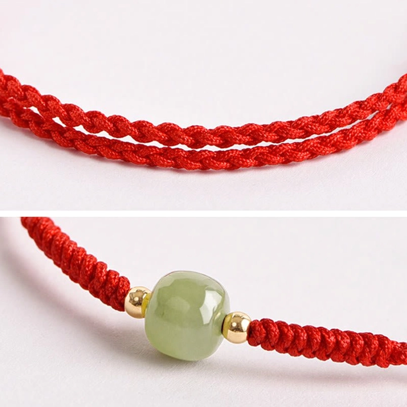Close-up detail of braided red cord and smooth jade bead with gold spacers