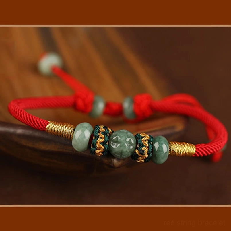 Jade red string bracelet placed on natural wooden surface lifestyle shot