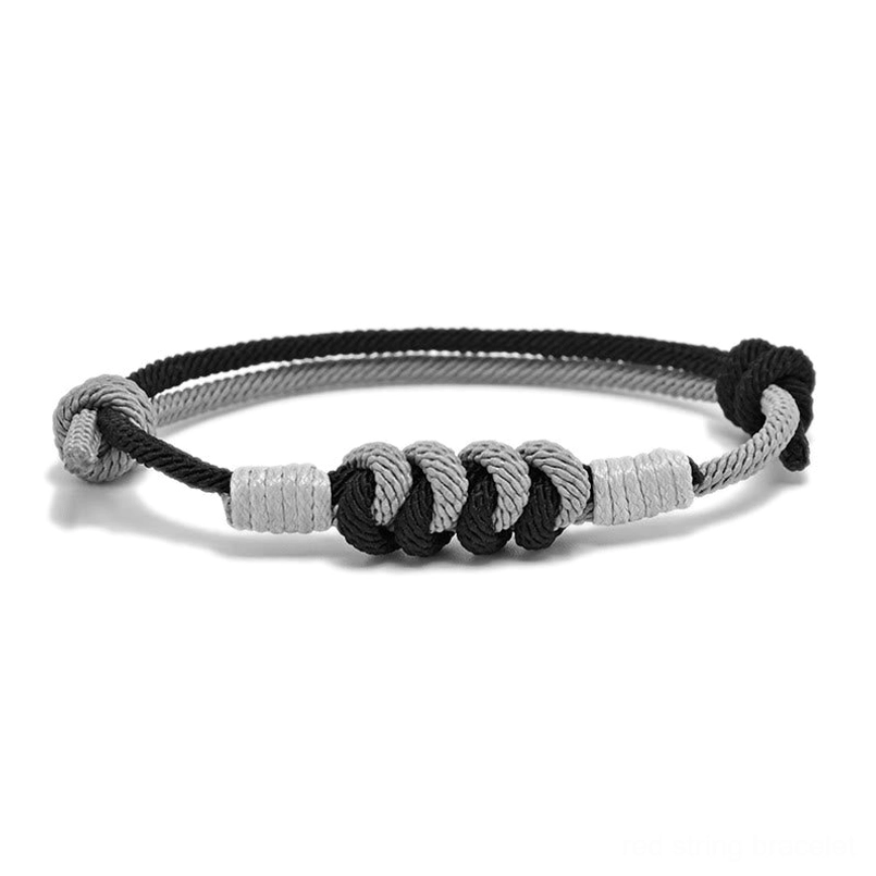 Black and gray braided King Kong knot spiritual bracelet, top-down flat lay on white background