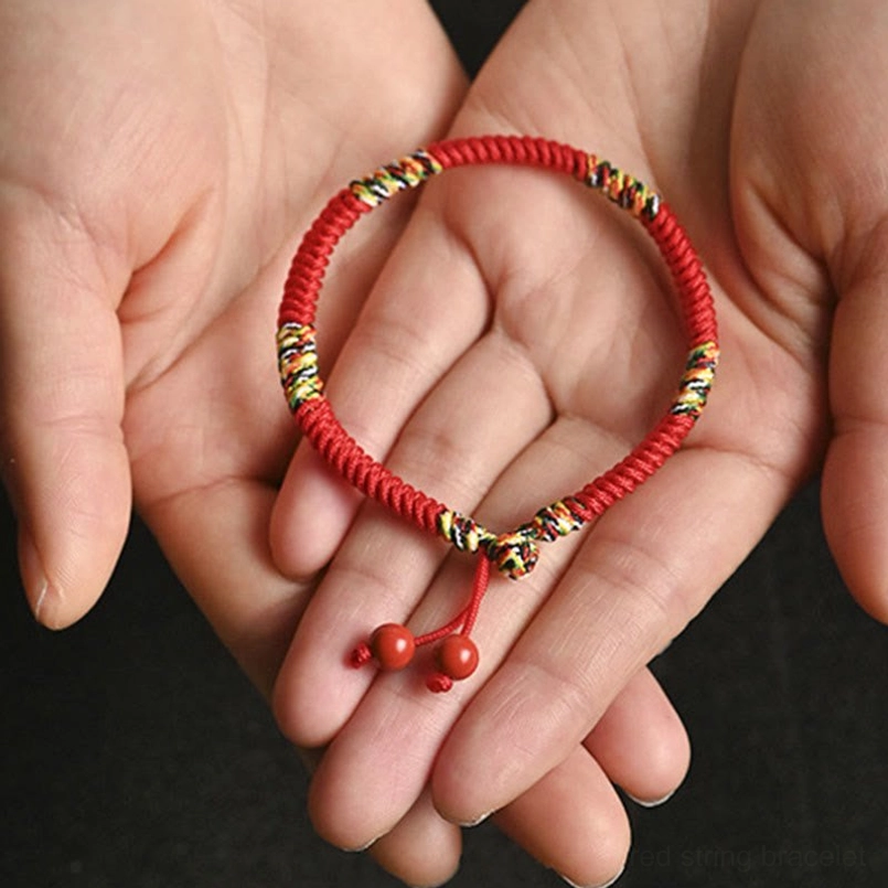 Dual hand palm display of five-color king kong knot bracelets with woven knot and cinnabar bead details