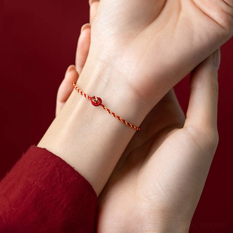 King Kong knot clasp on red braided luck bracelet, inner wrist detail