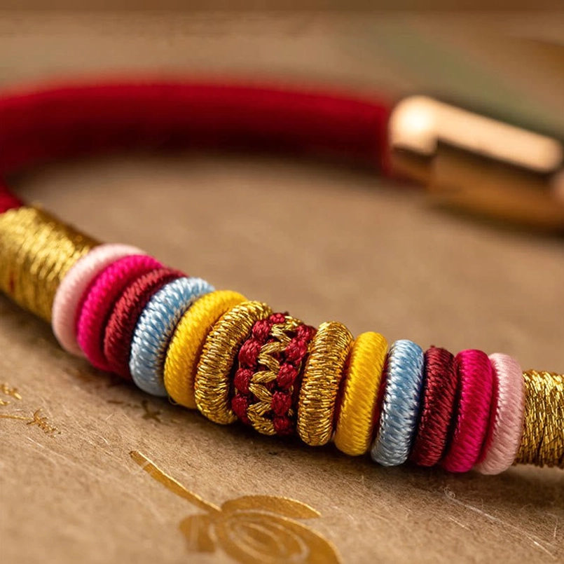 Macro close-up of King Kong Knot bracelet multicolor woven work with gold thread accents