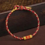 Handmade King Kong Knot Tibetan braided red string bracelet with gold knot accents front view