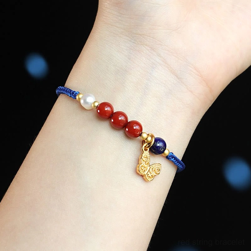Close up of klein blue gemstone bracelet worn on human wrist with butterfly charm