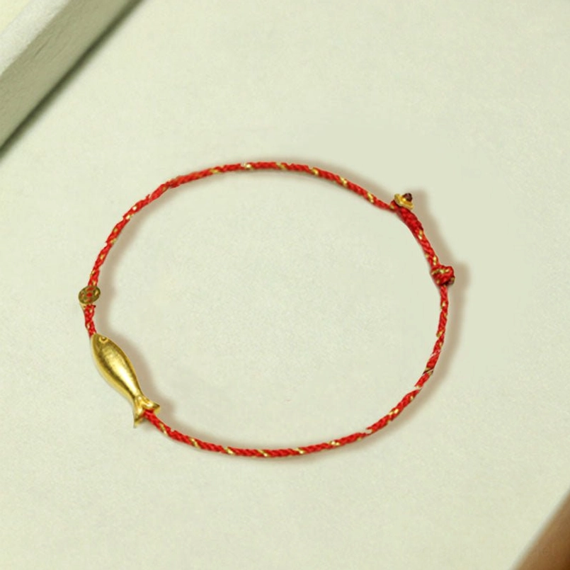 Koi fish prosperity bracelet worn with other rings and red sweater sleeve detail