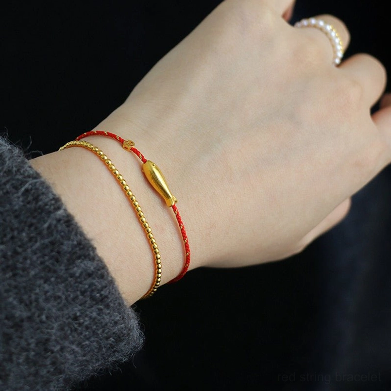 14K gold plated koi fish charm detail with red braided string bracelet