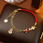 Koi fish gourd charm red string wealth bracelet with gold-plated chain and rhinestone - top-down view