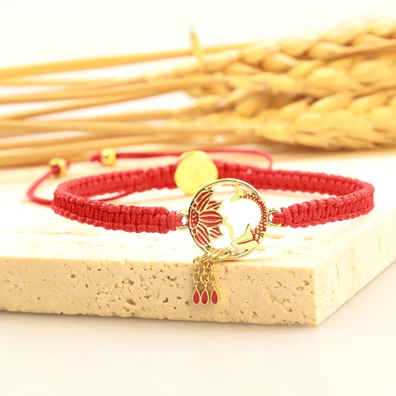Koi fish lotus red bracelet with gold hardware and tassel on wheat props - low angle detail