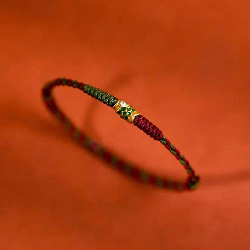 Low angle side view red green koi fish braided lucky bracelet