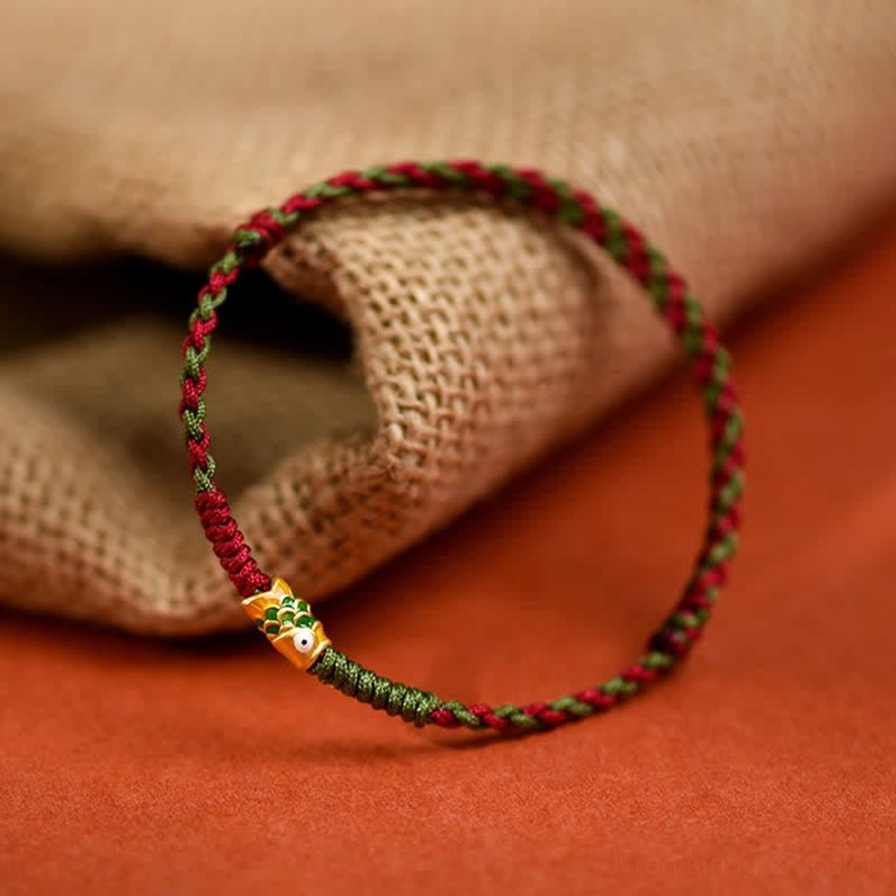 Red string koi fish bracelet closeup showing braided cord detail