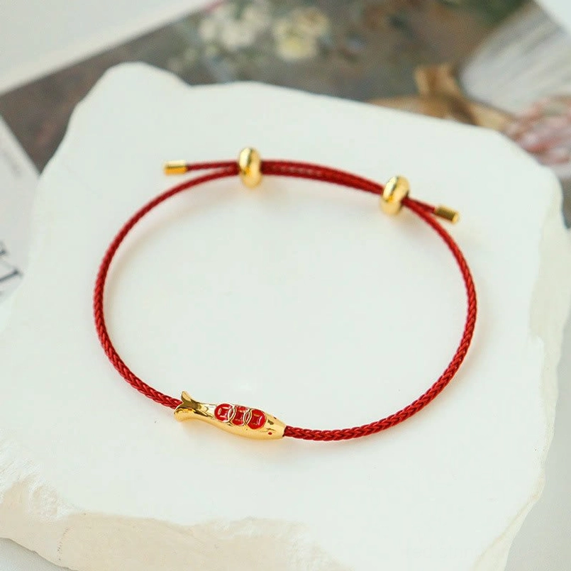 Koi fish red string lucky bracelet oblique top view on white display platform