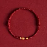 925 sterling silver koi fish red string bracelet with gold accents on wine red fabric background