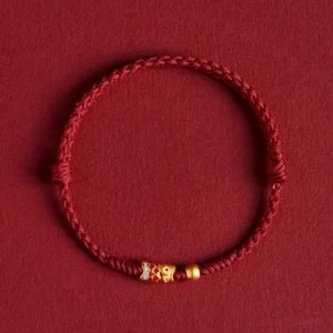 925 sterling silver koi fish red string bracelet with gold accents on wine red fabric background