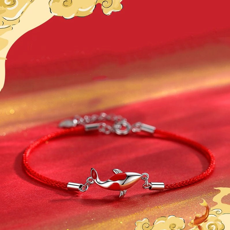 Single red koi braided bracelet with rose gold charm on festive red-gold background