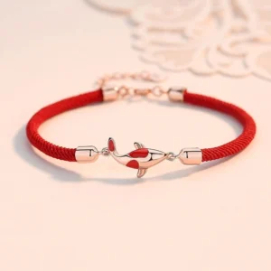 Rose gold koi fish red string couple bracelet with adjustable metal chain on lace background