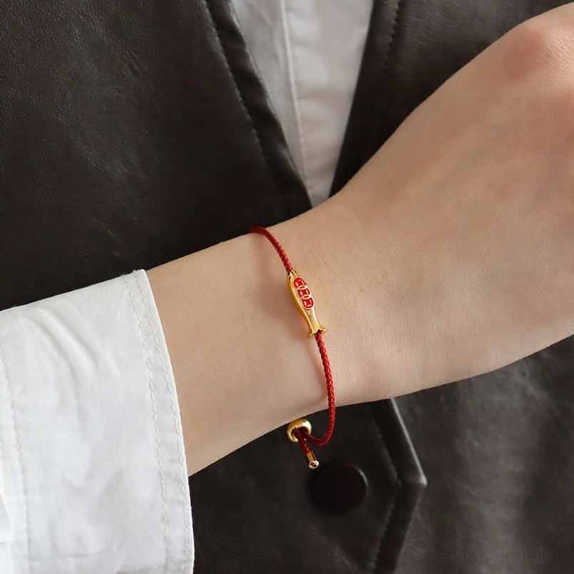 Koi fish red string bracelet worn on wrist close-up with casual outfit