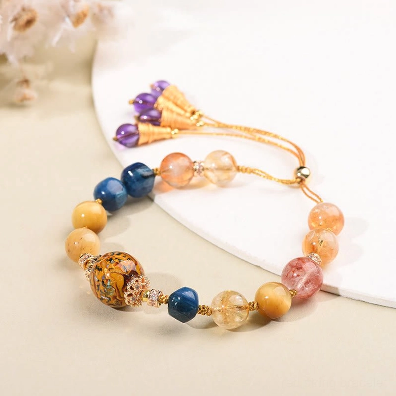Close-up detail of handcrafted mixed crystal bracelet showing carved lacquer centerpiece with gold spacers