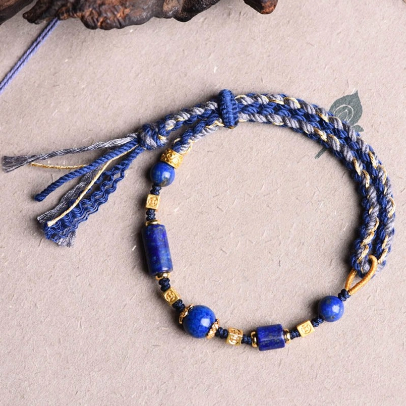 Flat lay of lapis lazuli red string bracelet showing complete tassel design