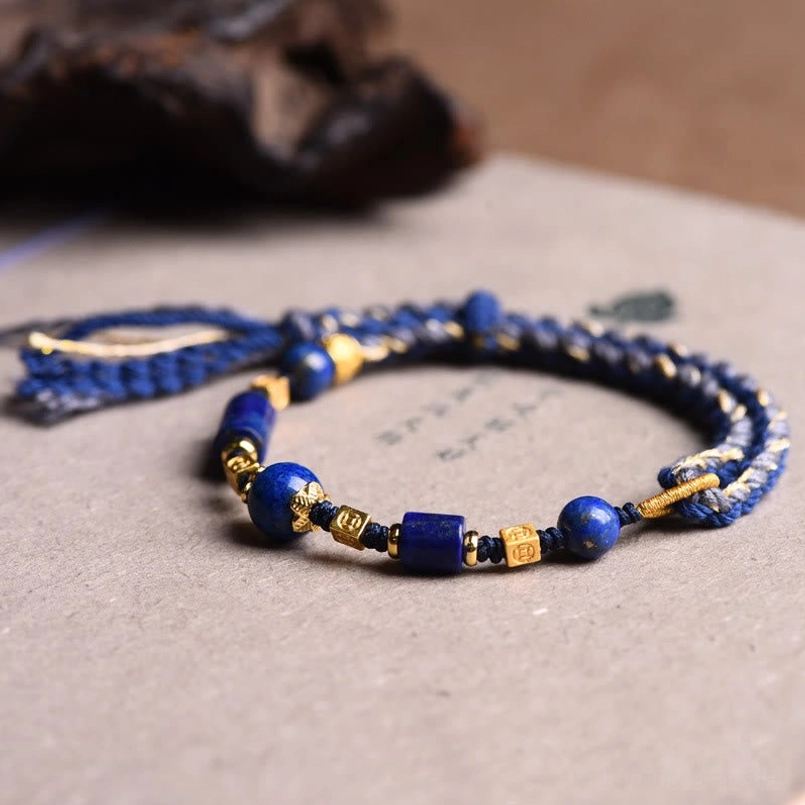 Lapis lazuli healing bracelet with natural hanging tassels on light background