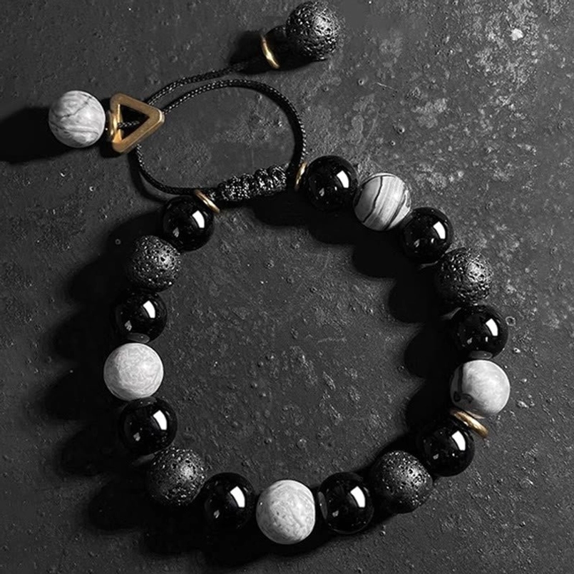 Lava rock Yin Yang bracelet top down flat lay on dark stone table