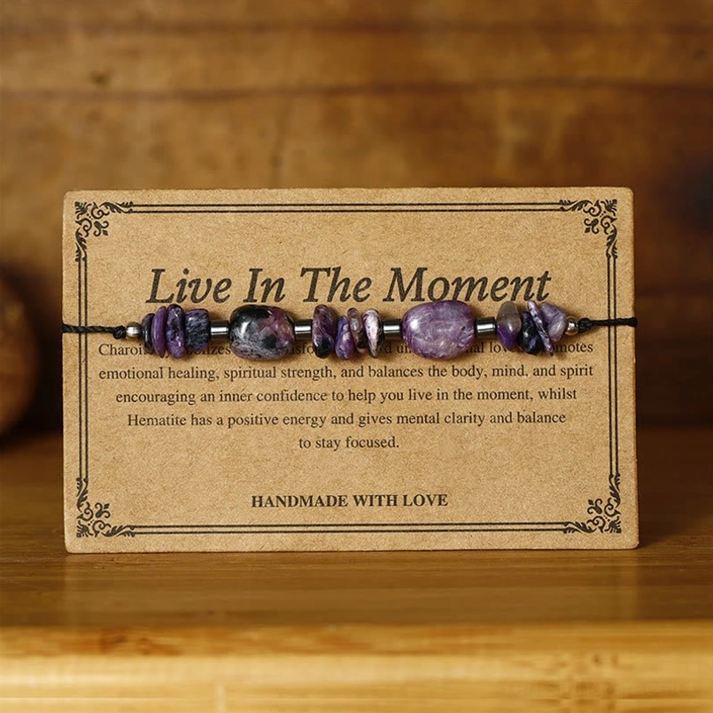 Handcrafted healing bracelet featuring purple charoite and dark hematite beads on kraft card