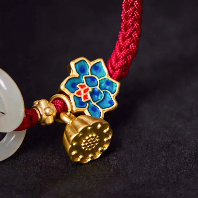 Macro close-up of enameled lotus charm and jade peace buckle with embossed metal details