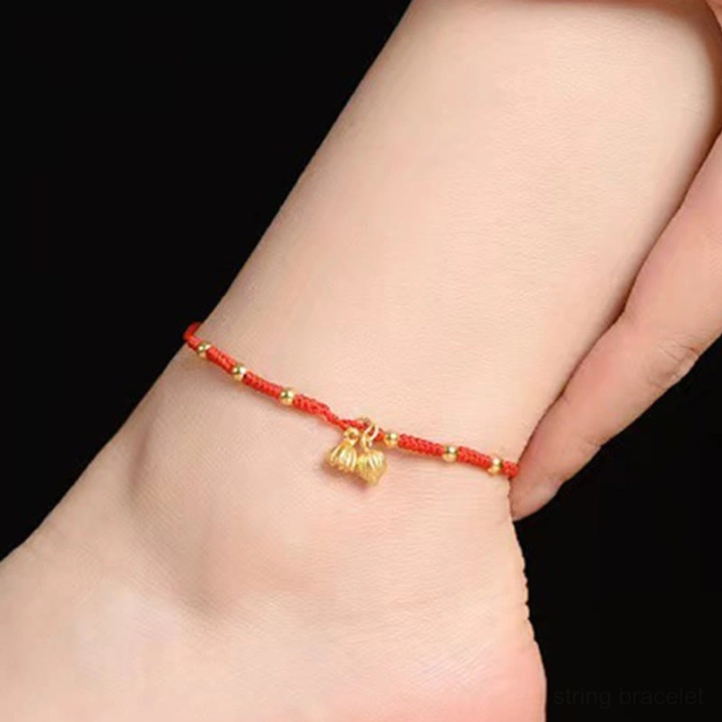 Red lotus pod charm anklet worn on ankle with gold beads on woven string