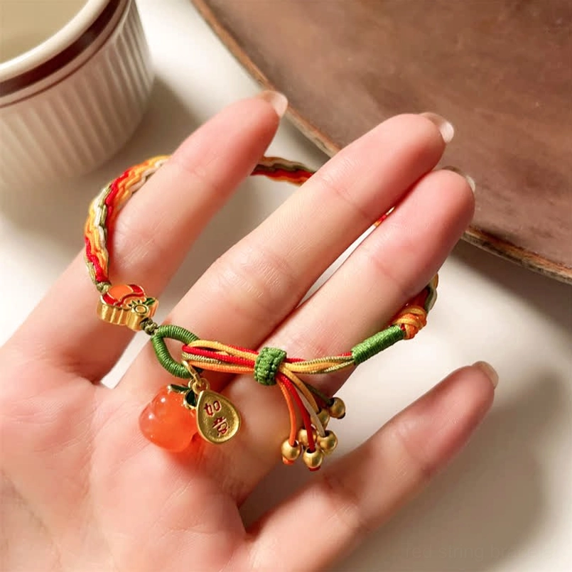 Handwoven red string bracelet on hand with multicolor weave and agate charm on calligraphy background