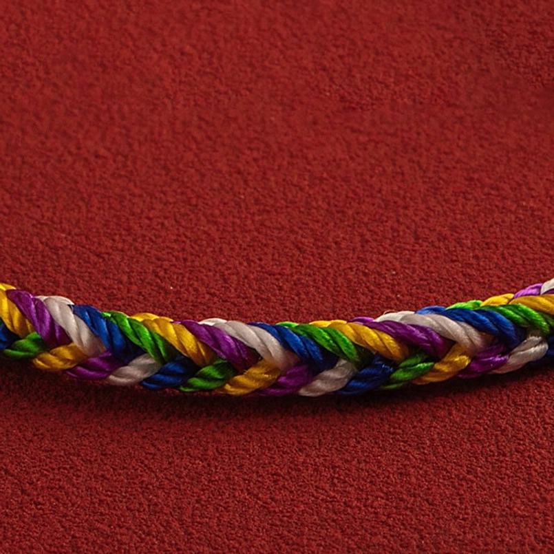 Close-up detail of multicolor braided lucky rope threads and weave pattern