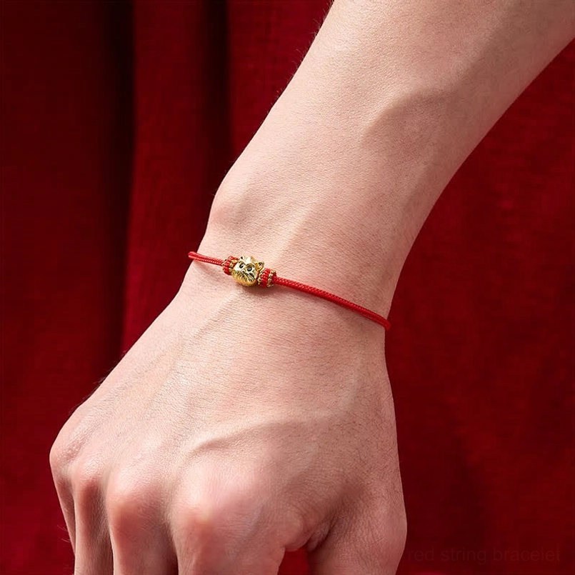 Lucky cat red string bracelet worn on wrist showing delicate cord and pendant