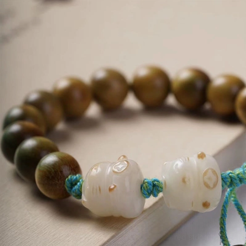 Lucky cat bead charm detail on green sandalwood woven cord bracelet