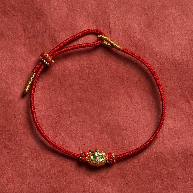 Full lucky cat red string bracelet with sliding clasp on solid background