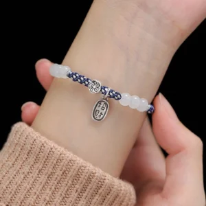 Handmade lucky fortune rope bracelet worn on wrist showing navy-white braided design with white beads and silver Chinese character pendant